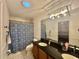 Bathroom featuring double sink vanity, vanity lighting, toilet and blue and white shower curtain at 243 Country Landing Blvd, Apopka, FL 32703