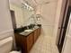 Bathroom featuring a double sink vanity with black countertop, tiled floor, and decorative light fixture at 243 Country Landing Blvd, Apopka, FL 32703