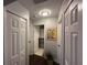 Hallway with multiple doors, grey walls, wood floors and a modern art piece at 243 Country Landing Blvd, Apopka, FL 32703