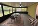 Enclosed patio featuring a ceiling fan, outdoor dining set, and a view of the backyard at 243 Country Landing Blvd, Apopka, FL 32703