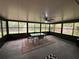 Enclosed porch offers a relaxing space with ceiling fan, large windows and a table with chairs at 243 Country Landing Blvd, Apopka, FL 32703