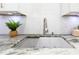 Close-up of a kitchen sink with granite countertops, stainless steel faucet, and white subway tile backsplash at 2550 Barren Oak Ct, Deland, FL 32720