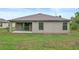 Back exterior of the home featuring a covered patio, sliding glass door, manicured lawn, and exterior lighting at 269 Fig Ct, Kissimmee, FL 34759