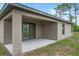 A covered back patio with concrete flooring, neutral toned siding, a sliding door, and grassy yard at 269 Fig Ct, Kissimmee, FL 34759
