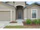 Close up of the front entrance, featuring an arched entryway and garden at 269 Fig Ct, Kissimmee, FL 34759