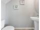 Half bath featuring a pedestal sink, toilet, neutral paint, and coastal-themed decorations at 2710 Golden Trout Ln, Edgewater, FL 32141