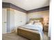 Comfortable bedroom showcasing a wooden bed frame, soft blue accents, and closet space at 2710 Golden Trout Ln, Edgewater, FL 32141