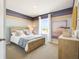 Inviting bedroom featuring a wooden bed frame, soft blue accents, and a window view at 2710 Golden Trout Ln, Edgewater, FL 32141