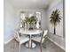 Bright dining area features a round table, modern chairs, decorative mirrors, and palm tree art for a stylish touch at 2710 Golden Trout Ln, Edgewater, FL 32141