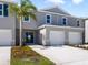Charming townhome featuring a two-car garage, manicured lawn, and a welcoming entrance, all bathed in sunlight at 2710 Golden Trout Ln, Edgewater, FL 32141
