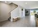 Light-filled foyer with staircase and console table in open layout, featuring tile floors, and view of backyard at 2710 Golden Trout Ln, Edgewater, FL 32141