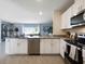 Well-lit kitchen with island overlooking the living space, featuring white cabinets and stainless appliances at 2710 Golden Trout Ln, Edgewater, FL 32141