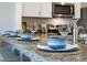 Close up of kitchen island with bowls and plates on the granite countertops, and barstool seating at 2710 Golden Trout Ln, Edgewater, FL 32141