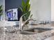 Close-up of kitchen island with granite countertops, sink, and decorative place settings at 2710 Golden Trout Ln, Edgewater, FL 32141