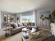 Bright and airy living room with backyard view, stylish decor, and open layout to the dining and kitchen areas at 2710 Golden Trout Ln, Edgewater, FL 32141