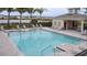 A community pool with clear water, surrounded by lounge chairs and a safety fence near a lake at 2710 Golden Trout Ln, Edgewater, FL 32141