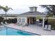 Poolside cabana with lounge chairs, tables, and chairs, surrounded by a safety fence at 2710 Golden Trout Ln, Edgewater, FL 32141