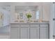 Well-lit bathroom featuring double vanity with granite countertop, white cabinets, and a large mirror at 279 Wisteria Ct, Deltona, FL 32738