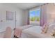 Bedroom featuring a large window with natural light, plush bedding, and soft, decorative curtains at 279 Wisteria Ct, Deltona, FL 32738
