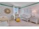 Bedroom features a white crib, a chair, neutral walls, and a decorative sun-shaped mirror at 279 Wisteria Ct, Deltona, FL 32738