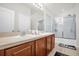 Bathroom featuring double sinks, wood cabinets, and a glass-enclosed shower at 2810 San Jacinto Cir # 2810, Sanford, FL 32771
