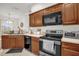 Well-lit kitchen with a black appliance suite, wood cabinets, and a clean tile floor at 2810 San Jacinto Cir # 2810, Sanford, FL 32771