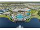 An aerial view of the clubhouse with a zero entry pool, palm trees, and lakeside views at 2960 Cherry Blossom Loop, St Cloud, FL 34771