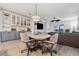 Open-concept dining area with a stylish light fixture and built-in shelving, adjacent to the living room at 2960 Cherry Blossom Loop, St Cloud, FL 34771