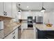 Bright kitchen featuring a granite countertop, stainless steel appliances, and white cabinets at 2960 Cherry Blossom Loop, St Cloud, FL 34771