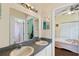 Bathroom featuring a dual sink vanity with a mirror, and a view of a bedroom at 322 Huron Dr, Kissimmee, FL 34759