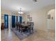 Open-concept dining room with tiled floors, chandelier, and blue curtains at 322 Huron Dr, Kissimmee, FL 34759