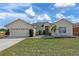 Charming single-story home featuring a well-maintained lawn and attached two-car garage at 322 Huron Dr, Kissimmee, FL 34759