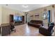 Cozy living room featuring tiled floors, a brown leather couch, and a built-in entertainment center at 322 Huron Dr, Kissimmee, FL 34759