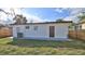View of the backyard and the rear elevation of the home with a brown door and manicured lawn at 326 Hobart Ave, Daytona Beach, FL 32114