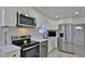 Modern kitchen features stainless steel appliances, white cabinetry, and quartz countertops at 326 Hobart Ave, Daytona Beach, FL 32114