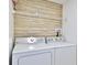Functional laundry room with wood paneling and a matching washer and dryer at 326 Hobart Ave, Daytona Beach, FL 32114