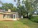 View of screened in back patio and back of the house in lush backyard at 345 Feather Pl, Longwood, FL 32779