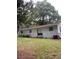 Back exterior view featuring a sliding glass door leading to the spacious backyard area at 3600 Ne 22Nd Ct, Ocala, FL 34479