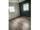 Spacious bedroom featuring wood-look flooring, two windows and modern ceiling fan at 3600 Ne 22Nd Ct, Ocala, FL 34479