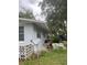 Side exterior of home with lush greenery, a DIRECTV dish, and car parked out front at 3600 Ne 22Nd Ct, Ocala, FL 34479