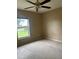Simple bedroom with a standard window offering natural light and a ceiling fan for air circulation at 42 Banyan Pass, Ocala, FL 34472