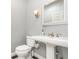 Charming powder room with a pedestal sink, wall sconce, and decorative mirror at 433 Tangerine Ave, Lake Helen, FL 32744