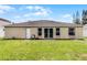 Rear view of house, showing the yard and glass sliding doors at 460 Flamingo Ct, Kissimmee, FL 34759