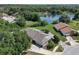 Aerial view showcasing a lakeside home surrounded by lush greenery and mature trees at 4643 Fern Pine Dr, Orlando, FL 32808