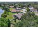 Aerial view of a home in a lush, tree-filled community with a nearby pond, showcasing the serene surroundings at 4643 Fern Pine Dr, Orlando, FL 32808