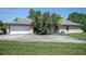 Charming home featuring a two-car garage, mature trees, and a spacious driveway and well-manicured lawn at 4643 Fern Pine Dr, Orlando, FL 32808