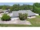 Aerial view of a home with a two-car garage, mature trees, and driveway at 4643 Fern Pine Dr, Orlando, FL 32808