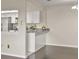 View of the kitchen from the living room featuring gray countertops and white cabinets, creating an open and connected space at 4643 Fern Pine Dr, Orlando, FL 32808
