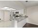 Updated kitchen with stainless steel appliances, white cabinets, and gray granite countertops with tile flooring at 4643 Fern Pine Dr, Orlando, FL 32808