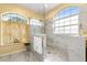 Bathroom featuring marble-look shower, tile floors, and arched windows at 507 Westwind Dr, Davenport, FL 33896